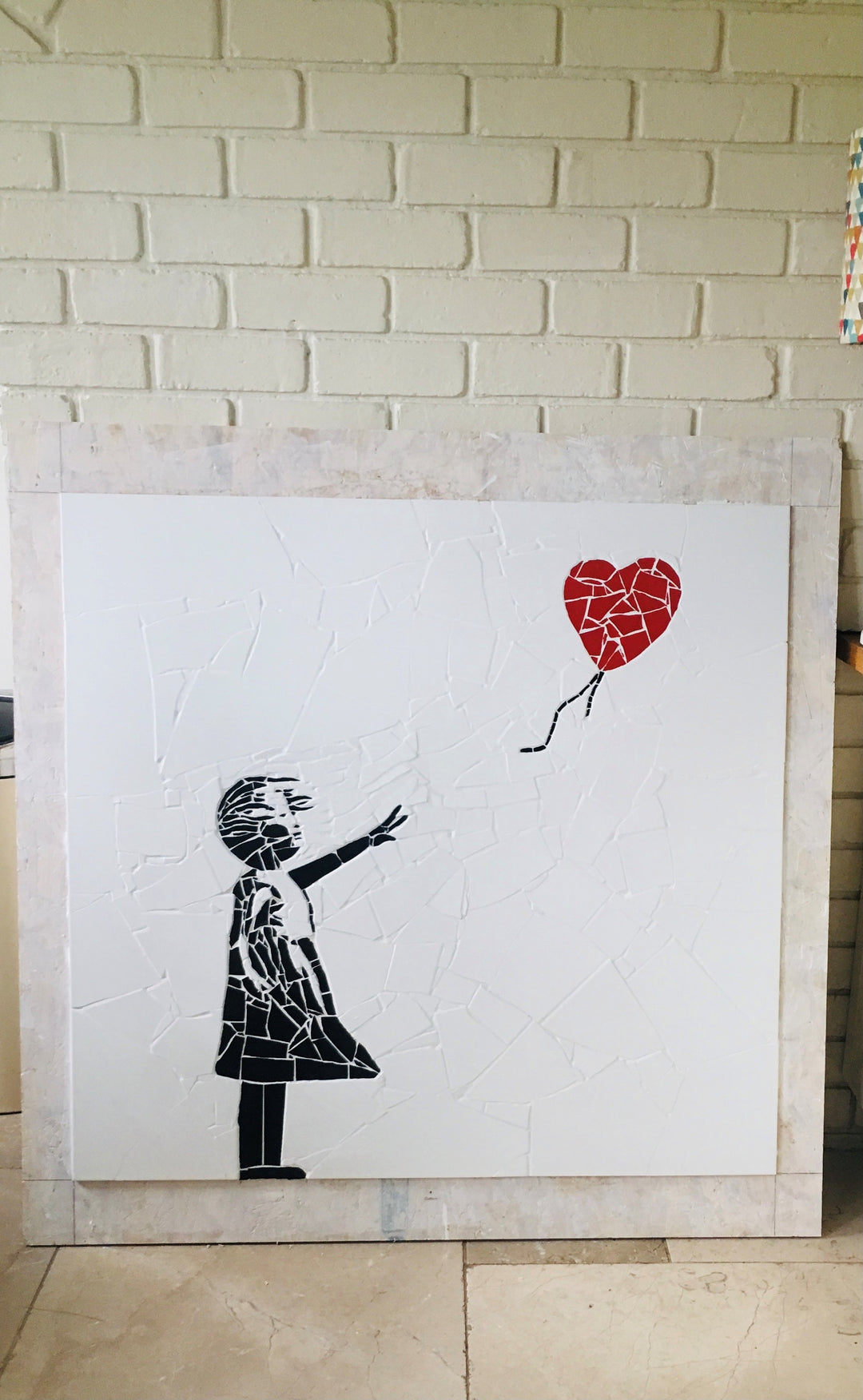 “Girl with Balloon” mosaic — a handcrafted ceramic tile artwork reimagining the iconic heart balloon image. Featuring black and white tiles with a vivid red heart, this bespoke commission blends street art symbolism with fine mosaic craftsmanship.