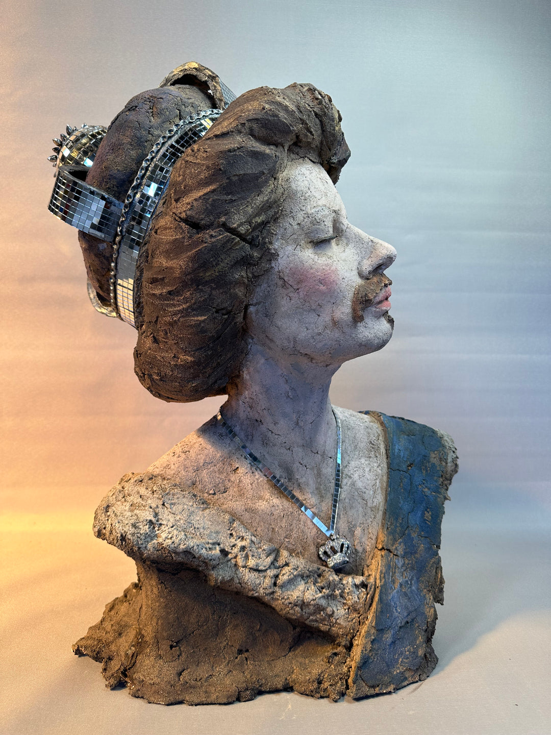 Contemporary ceramic bust sculpture by Eve Shepherd featuring a raw hand-built female figure wearing a mirrored mosaic crown, combining classical portraiture with modern satire, textured clay surfaces, reflective glass elements and irreverent royal symbolism