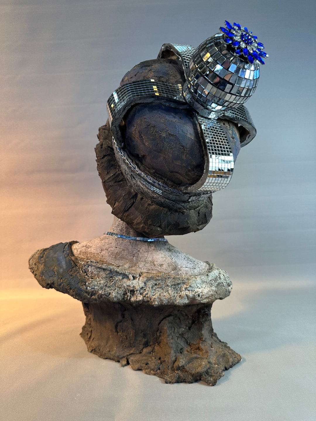 Contemporary ceramic bust sculpture by Eve Shepherd featuring a raw hand-built female figure wearing a mirrored mosaic crown, combining classical portraiture with modern satire, textured clay surfaces, reflective glass elements and irreverent royal symbolism