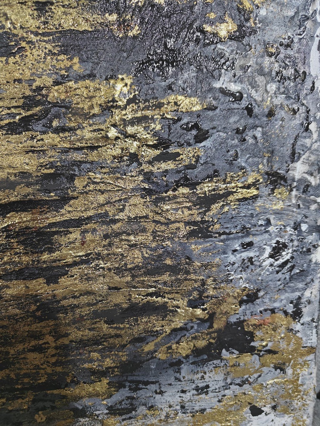 Textured abstract painting with vertical strokes in gold, black, and grey tones on a rough, layered surface