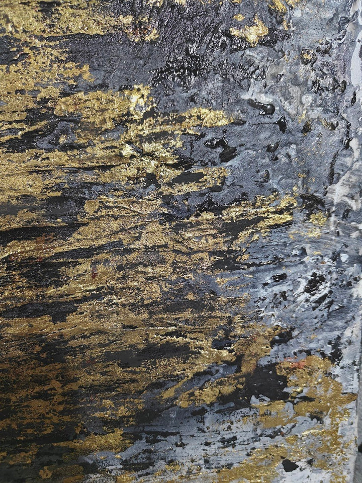 Textured abstract painting with vertical strokes in gold, black, and grey tones on a rough, layered surface