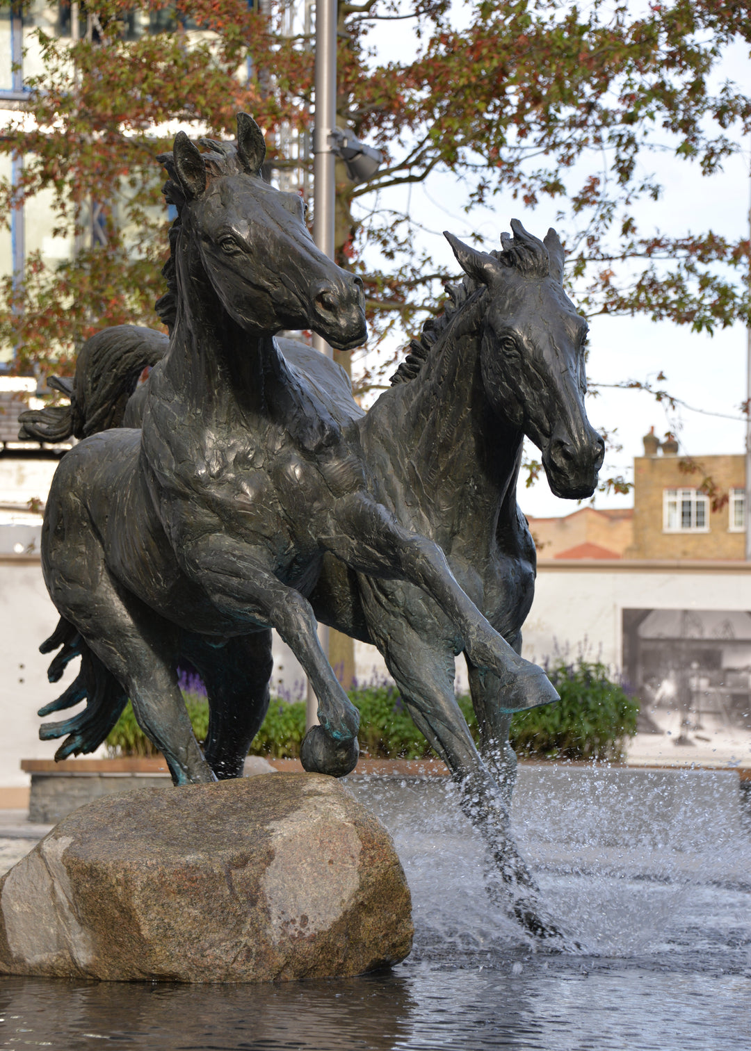 ‘Goodman's Horses Running Together’ by Hamish Mackie, a monumental limited-edition bronze sculpture depicting two powerful horses, a thoroughbred and a shire-cross, galloping together through water. Originally commissioned for Goodman's Fields in London, the dynamic public artwork captures muscular movement, flowing manes and the energy of horses in motion, finished in dark patinated bronze.