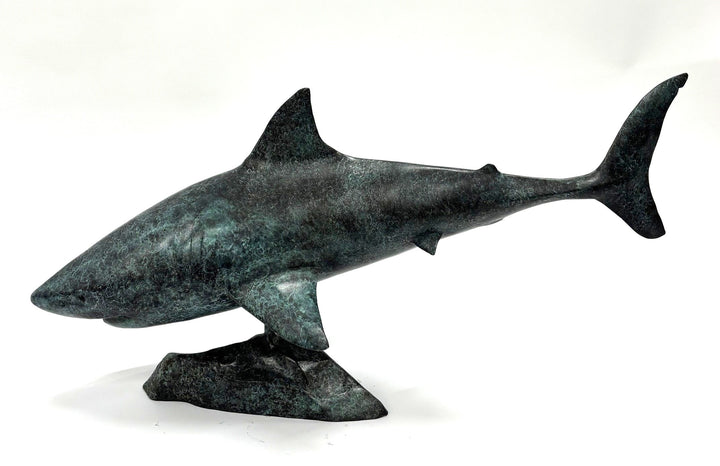 Bronze sculpture of a shark captured mid-motion, mounted on a textured base and finished in a deep mottled patina, cast as a limited edition artwork.