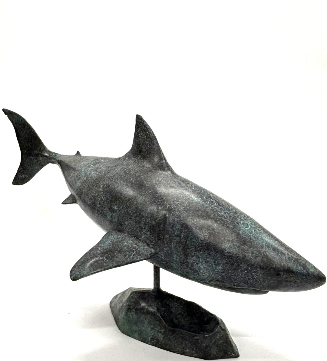 Bronze sculpture of a shark captured mid-motion, mounted on a textured base and finished in a deep mottled patina, cast as a limited edition artwork.