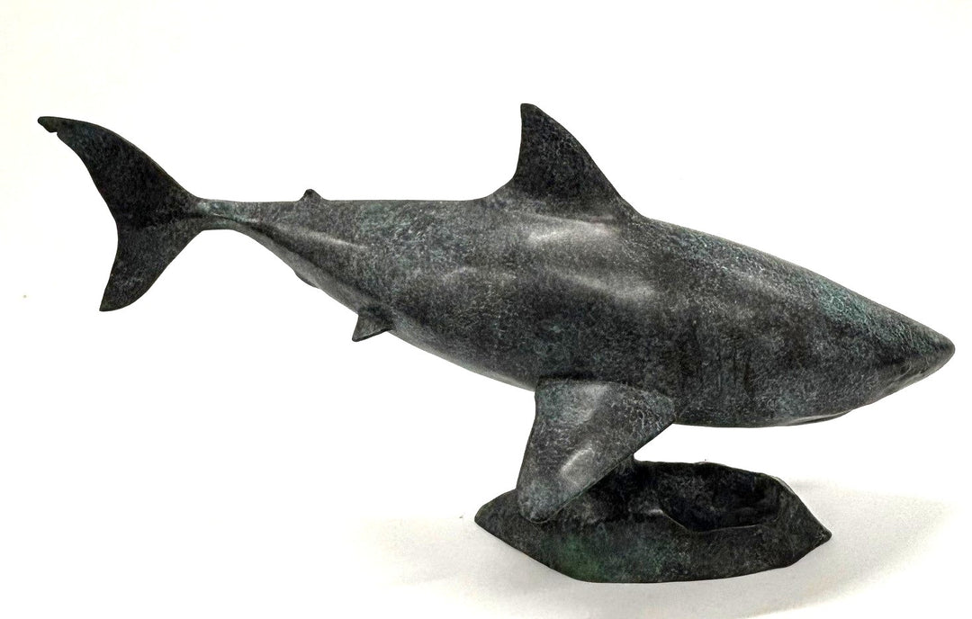 Bronze sculpture of a shark captured mid-motion, mounted on a textured base and finished in a deep mottled patina, cast as a limited edition artwork.