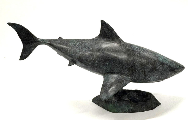Bronze sculpture of a shark captured mid-motion, mounted on a textured base and finished in a deep mottled patina, cast as a limited edition artwork.