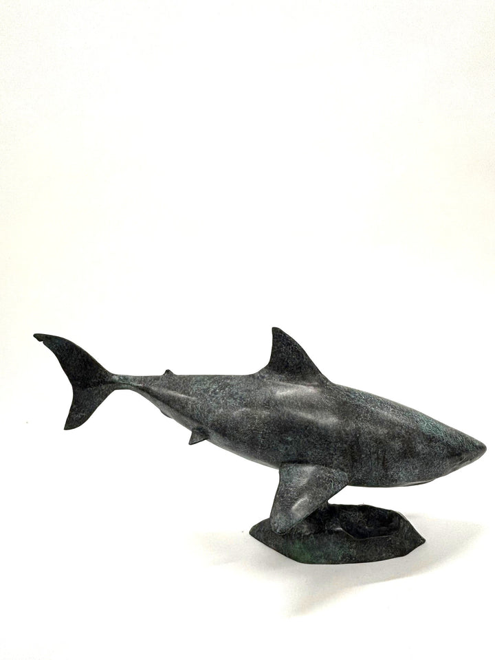 Bronze sculpture of a shark captured mid-motion, mounted on a textured base and finished in a deep mottled patina, cast as a limited edition artwork.