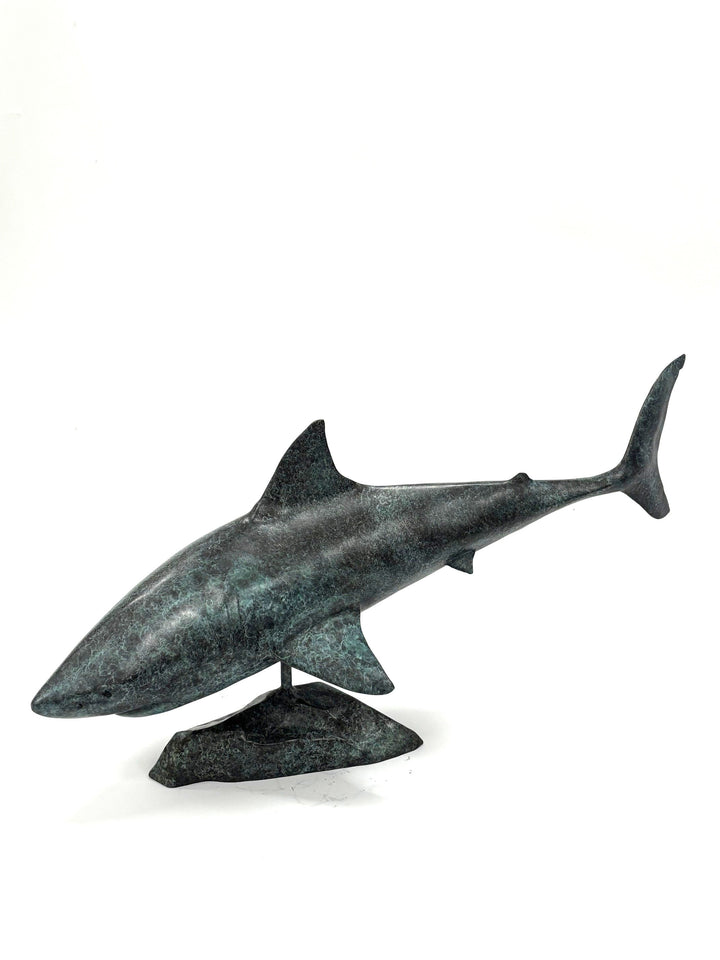 Bronze sculpture of a shark captured mid-motion, mounted on a textured base and finished in a deep mottled patina, cast as a limited edition artwork.