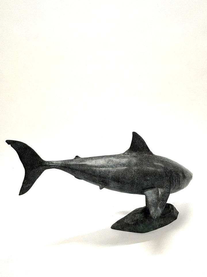 Bronze sculpture of a shark captured mid-motion, mounted on a textured base and finished in a deep mottled patina, cast as a limited edition artwork.
