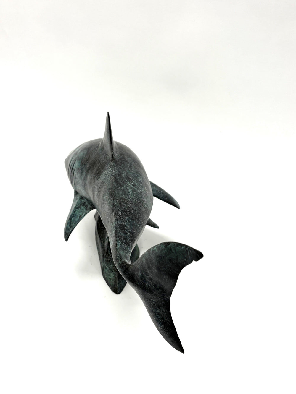 Bronze sculpture of a shark captured mid-motion, mounted on a textured base and finished in a deep mottled patina, cast as a limited edition artwork.