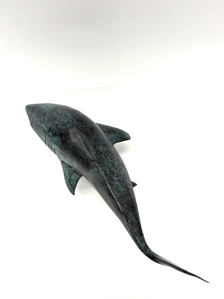 Bronze sculpture of a shark captured mid-motion, mounted on a textured base and finished in a deep mottled patina, cast as a limited edition artwork.