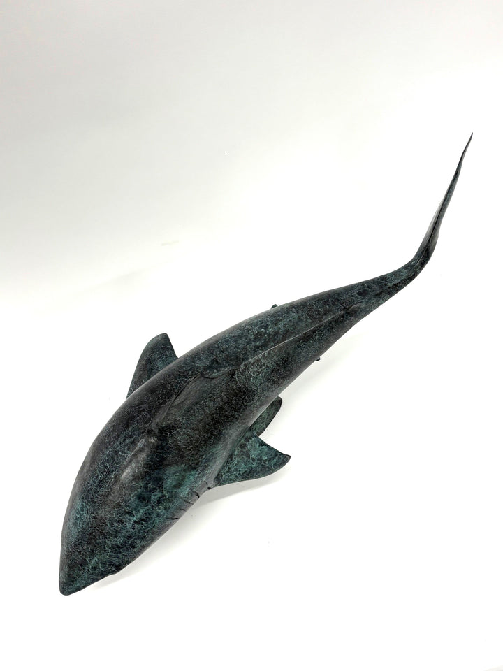 Bronze sculpture of a shark captured mid-motion, mounted on a textured base and finished in a deep mottled patina, cast as a limited edition artwork.
