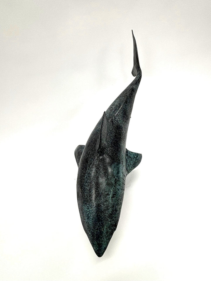 Bronze sculpture of a shark captured mid-motion, mounted on a textured base and finished in a deep mottled patina, cast as a limited edition artwork.
