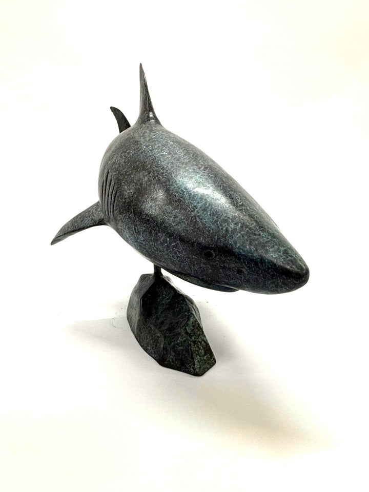 Bronze sculpture of a shark captured mid-motion, mounted on a textured base and finished in a deep mottled patina, cast as a limited edition artwork.