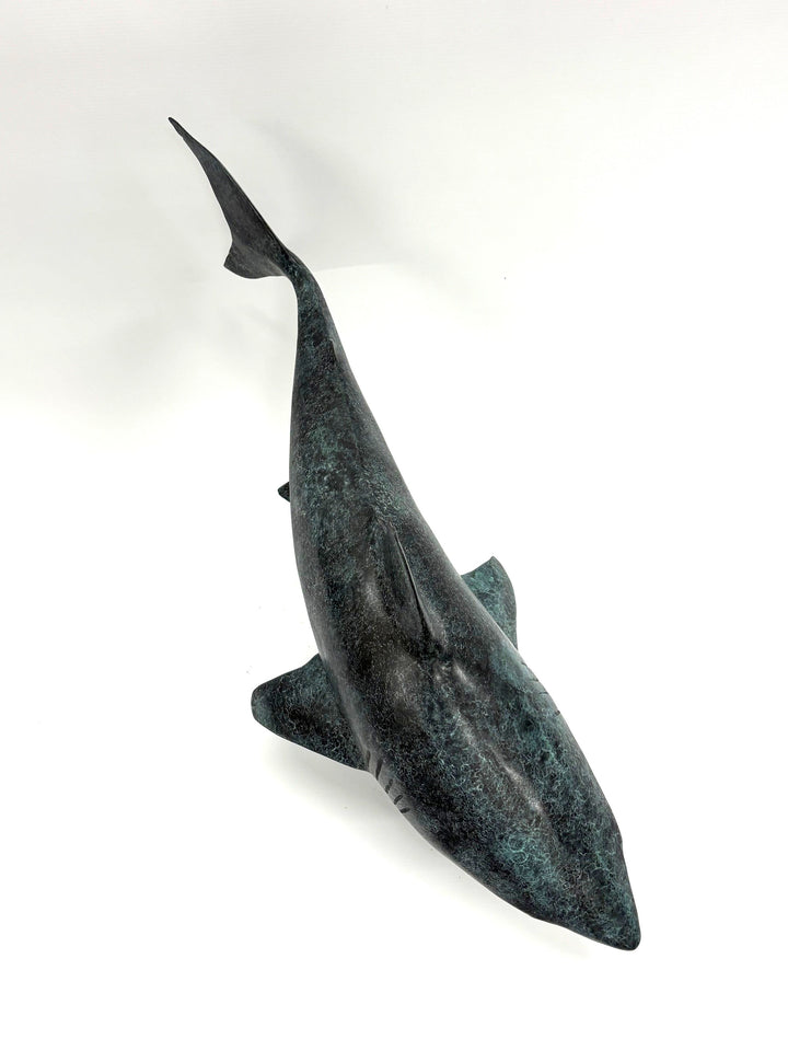 Bronze sculpture of a shark captured mid-motion, mounted on a textured base and finished in a deep mottled patina, cast as a limited edition artwork.