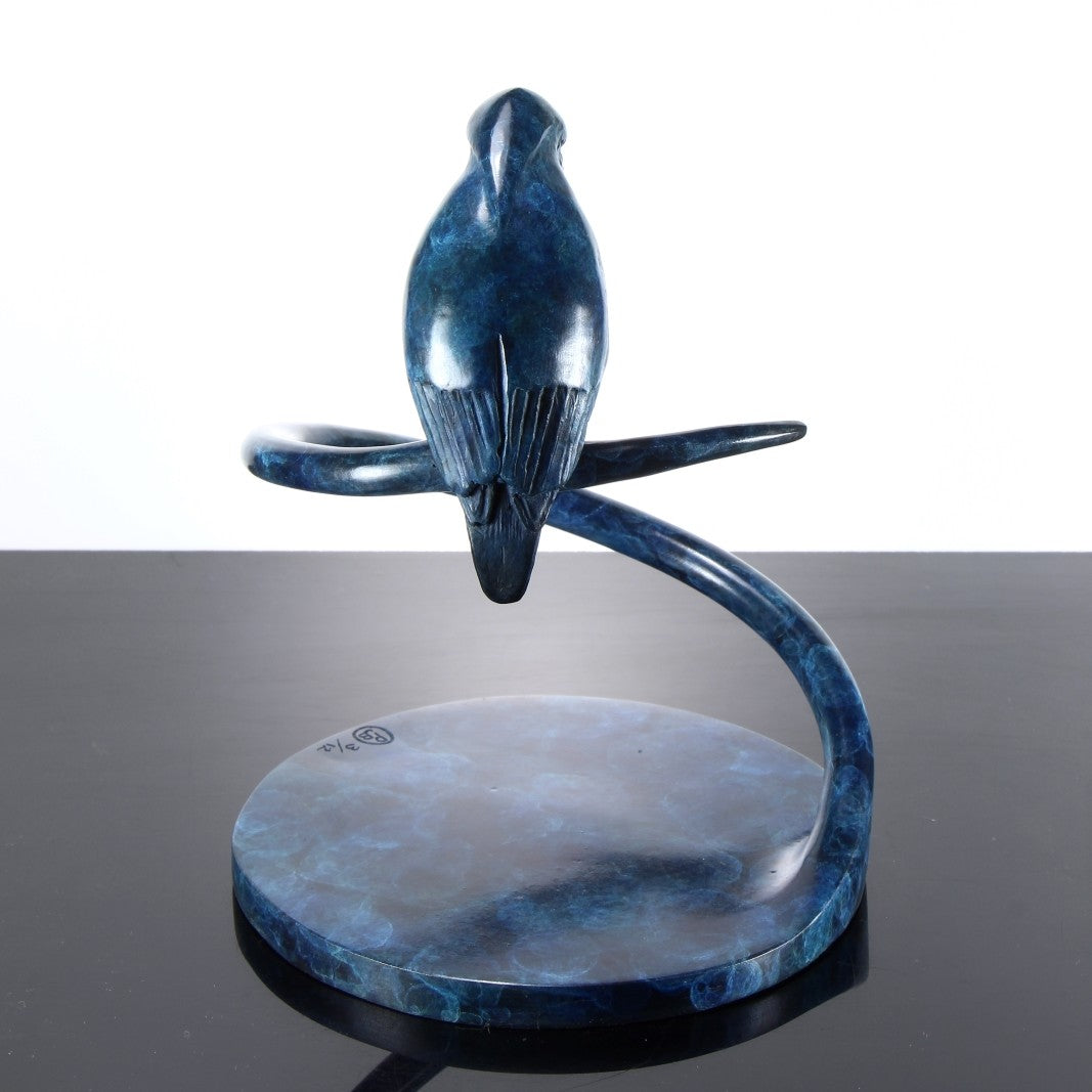 ‘Halcyon Days Maquette’ by Pat Bull, a limited-edition contemporary bronze wildlife sculpture depicting a kingfisher perched on a sweeping spiral bronze support, its head lowered and pointed beak angled towards the circular base below. The bird features finely detailed wing feathers and a smooth, rounded body finished in deep blue, navy and turquoise patina. The curved bronze stem and circular base share a mottled blue-green finish, creating a compact, elegant sculpture inspired by British wildlife.