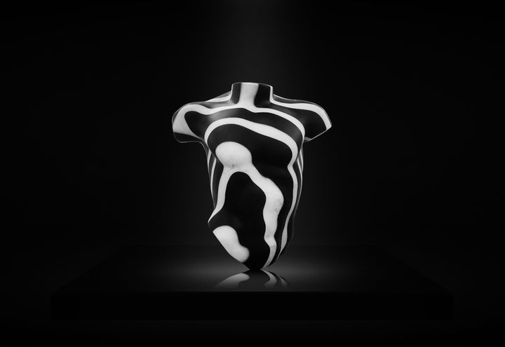 Striking male torso sculpture crafted from Italian white marble and slate, featuring bold organic contour lines in high-contrast black and white, displayed on a dedicated base for interior presentation.