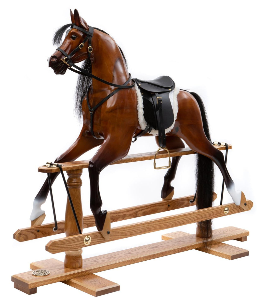 Glossy dark wood rocking horse with flowing black mane, black saddle, and white sheepskin numnah on a traditional oak safety stand.

