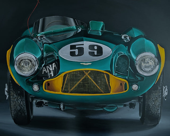 Hyper-realistic painting of a classic British racing green Aston Martin DB3S front-on against a deep black background, with a shiny metallic green frog-shaped balloon floating above the car, its red string tied to the vehicle — a playful contrast of automotive heritage and childlike whimsy.