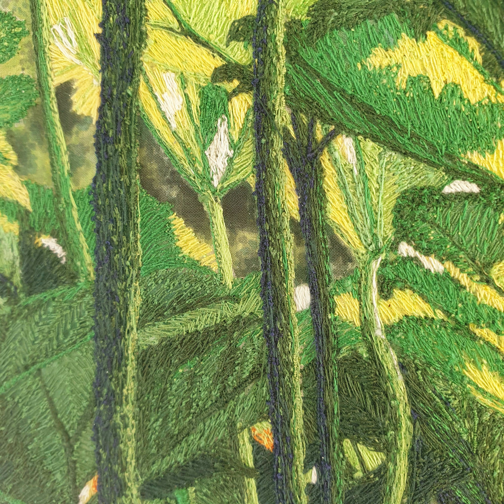 Dense embroidered scene of tropical foliage with overlapping green and yellow leaves viewed from beneath a lush canopy.
