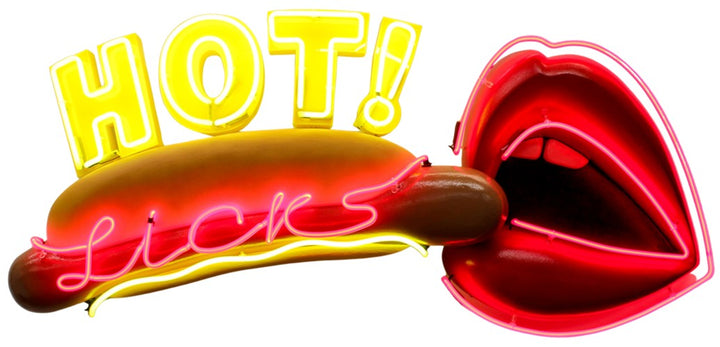 Playful neon wall art by Chris Bracey featuring a hot dog with the words “HOT Licks” in glowing yellow and pink neon, paired with a bold red neon mouth and lips design. Sculptural elements include a fabricated hot dog and 3D lips, combining humour and innuendo in classic Bracey style.