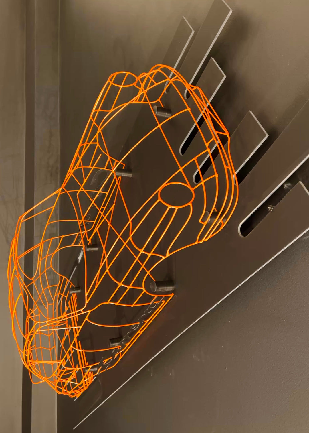 Handcrafted Porsche 911 2.7 RS wire sculpture by Chris Twitchell, finished in vivid Tangerine orange with black Carrera script. This detailed artwork captures the iconic pre-impact bumper 911 form — from its classic round headlights to the signature ducktail spoiler — reimagined as a precision-engineered wireframe sculpture that celebrates Porsche’s timeless design and performance heritage.