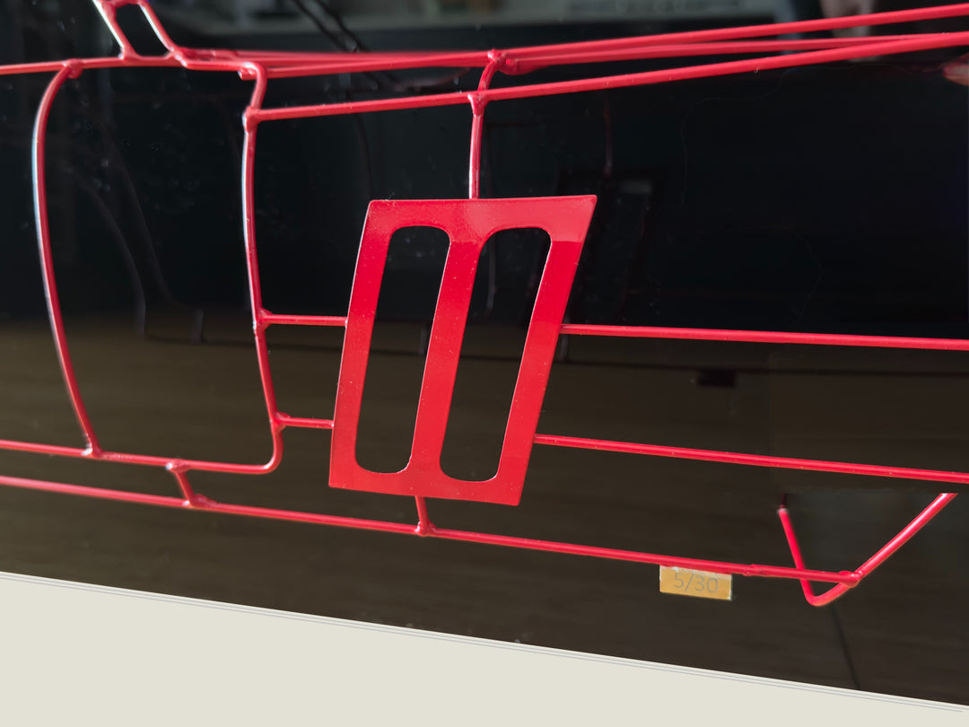 Handcrafted Ferrari 250 GTO wire sculpture by Chris Twitchell, capturing the elegant profile of the legendary 1962 Series 1 Scaglietti body. Finished in Rosso Chiaro red and mounted on a sleek black panel, this sculptural study reimagines the original Maranello buck in minimalist wire form — a fusion of precision engineering, Italian design, and contemporary British craftsmanship.