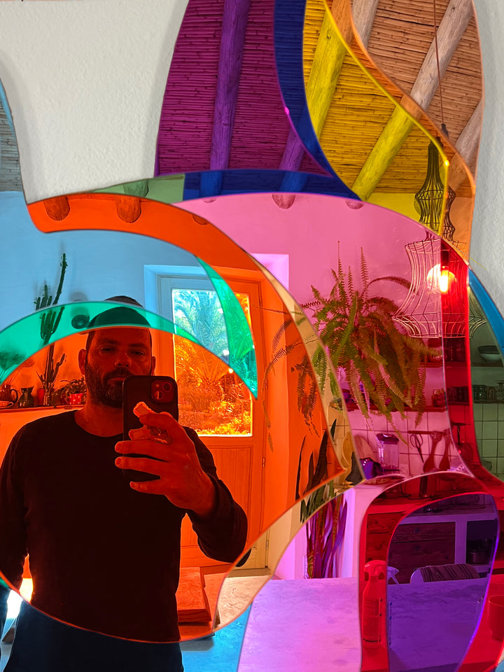Vibrant, multi-coloured wall sculpture by Yoni Alter in the shape of a stylised French Bulldog, crafted from layered acrylic mirrors with bold, fluid contours and a high-gloss finish. The reflective surfaces create playful distortions of light and environment, merging pop art energy with contemporary design.