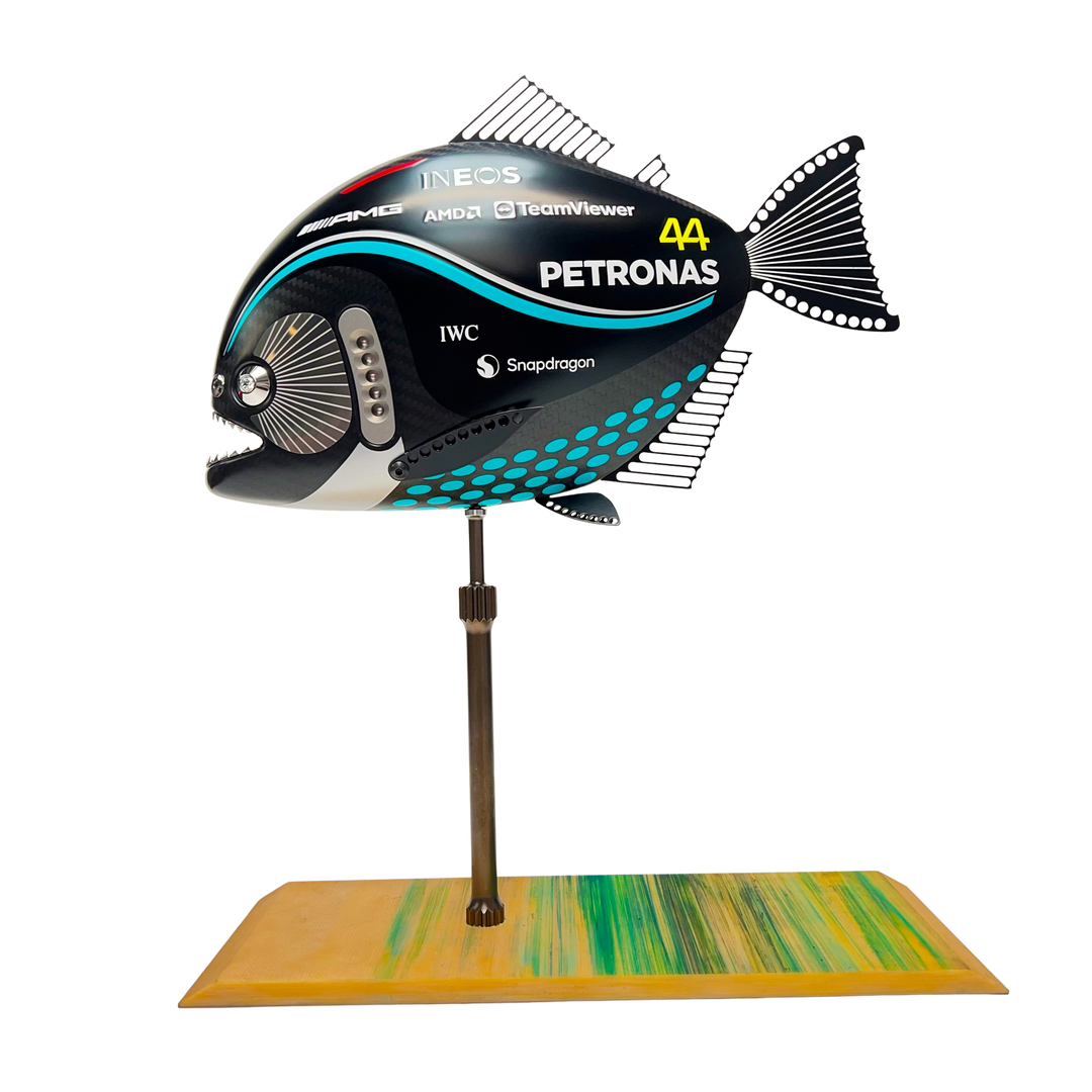 Close-up views of Predator in Motion – a sculptural fusion of engineering and marine form by Alastair Gibson. The body is formed from layered carbon fibre with a matte black finish and turquoise vinyl livery inspired by Lewis Hamilton’s 2023 Mercedes AMG Formula One car. Sponsor graphics include Petronas, Ineos, AMD, and TeamViewer. Satin black stainless steel fins and titanium teeth reflect precision F1 detailing. Polished titanium eyes are inset with a pink diamond-effect crystal. Mounted on a torsion bar