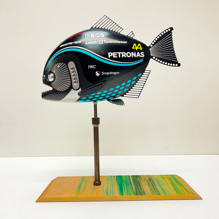 Close-up views of Predator in Motion – a sculptural fusion of engineering and marine form by Alastair Gibson. The body is formed from layered carbon fibre with a matte black finish and turquoise vinyl livery inspired by Lewis Hamilton’s 2023 Mercedes AMG Formula One car. Sponsor graphics include Petronas, Ineos, AMD, and TeamViewer. Satin black stainless steel fins and titanium teeth reflect precision F1 detailing. Polished titanium eyes are inset with a pink diamond-effect crystal. Mounted on a torsion bar