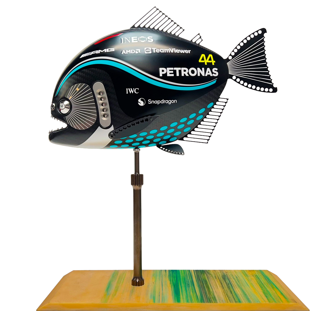 Close-up views of Predator in Motion – a sculptural fusion of engineering and marine form by Alastair Gibson. The body is formed from layered carbon fibre with a matte black finish and turquoise vinyl livery inspired by Lewis Hamilton’s 2023 Mercedes AMG Formula One car. Sponsor graphics include Petronas, Ineos, AMD, and TeamViewer. Satin black stainless steel fins and titanium teeth reflect precision F1 detailing. Polished titanium eyes are inset with a pink diamond-effect crystal. Mounted on a torsion bar