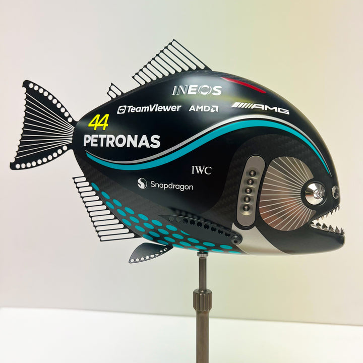 Close-up views of Predator in Motion – a sculptural fusion of engineering and marine form by Alastair Gibson. The body is formed from layered carbon fibre with a matte black finish and turquoise vinyl livery inspired by Lewis Hamilton’s 2023 Mercedes AMG Formula One car. Sponsor graphics include Petronas, Ineos, AMD, and TeamViewer. Satin black stainless steel fins and titanium teeth reflect precision F1 detailing. Polished titanium eyes are inset with a pink diamond-effect crystal. Mounted on a torsion bar