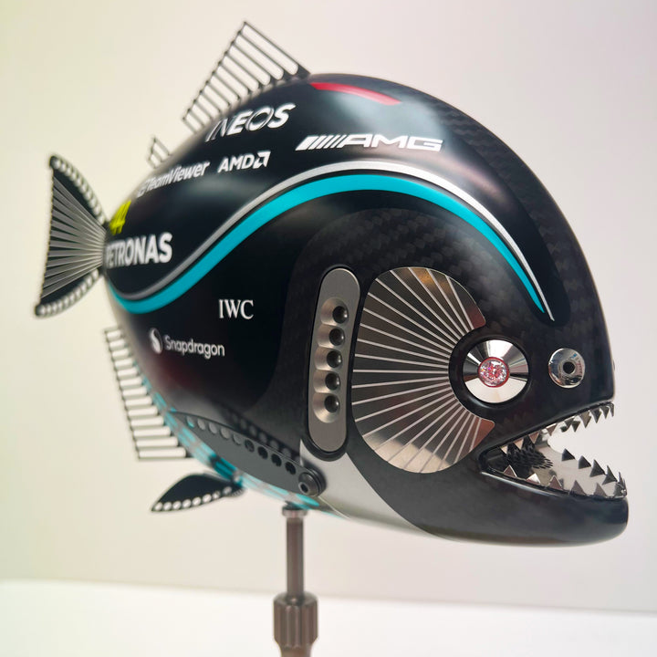 Close-up views of Predator in Motion – a sculptural fusion of engineering and marine form by Alastair Gibson. The body is formed from layered carbon fibre with a matte black finish and turquoise vinyl livery inspired by Lewis Hamilton’s 2023 Mercedes AMG Formula One car. Sponsor graphics include Petronas, Ineos, AMD, and TeamViewer. Satin black stainless steel fins and titanium teeth reflect precision F1 detailing. Polished titanium eyes are inset with a pink diamond-effect crystal. Mounted on a torsion bar