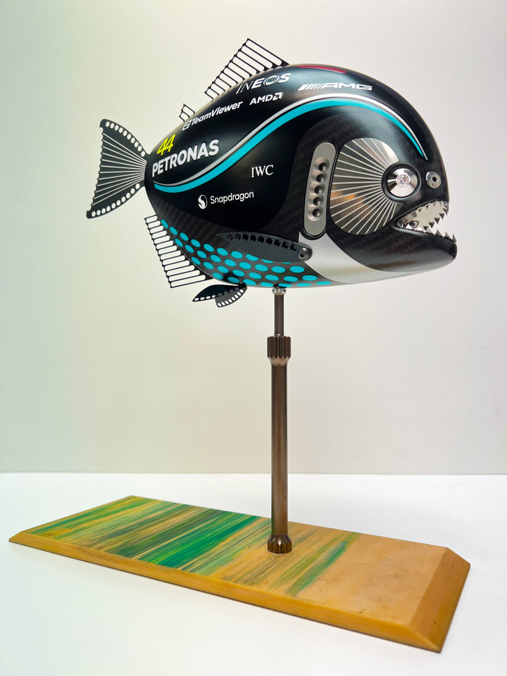 Close-up views of Predator in Motion – a sculptural fusion of engineering and marine form by Alastair Gibson. The body is formed from layered carbon fibre with a matte black finish and turquoise vinyl livery inspired by Lewis Hamilton’s 2023 Mercedes AMG Formula One car. Sponsor graphics include Petronas, Ineos, AMD, and TeamViewer. Satin black stainless steel fins and titanium teeth reflect precision F1 detailing. Polished titanium eyes are inset with a pink diamond-effect crystal. Mounted on a torsion bar