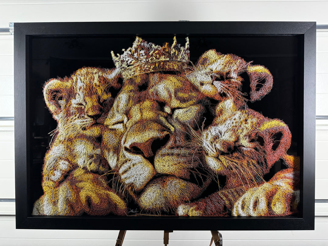A richly textured injected-scribble artwork depicting a majestic lion wearing a crown, resting peacefully with three lion cubs nestled against him. The composition glows with warm tones of gold, amber, orange and cream, set against a deep black background that enhances the dimensional, thread-like detailing.