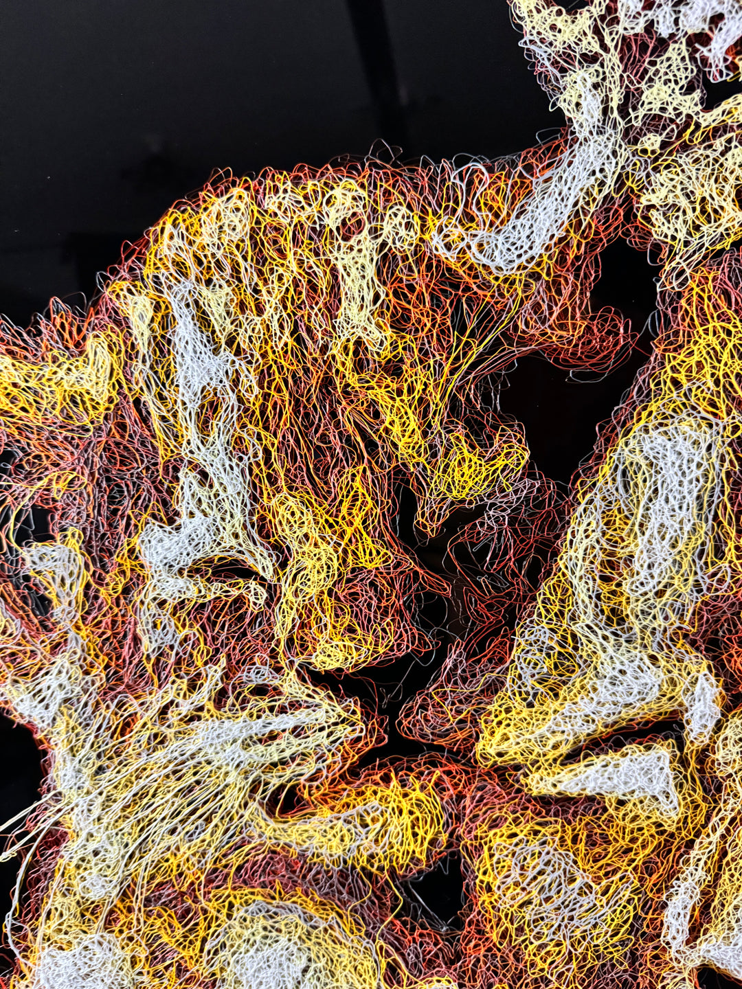 A richly textured injected-scribble artwork depicting a majestic lion wearing a crown, resting peacefully with three lion cubs nestled against him. The composition glows with warm tones of gold, amber, orange and cream, set against a deep black background that enhances the dimensional, thread-like detailing.