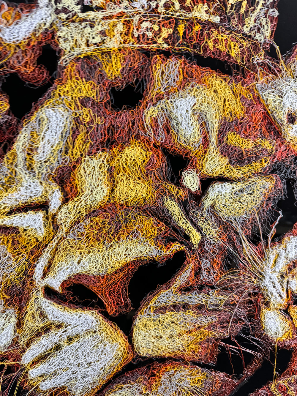 A richly textured injected-scribble artwork depicting a majestic lion wearing a crown, resting peacefully with three lion cubs nestled against him. The composition glows with warm tones of gold, amber, orange and cream, set against a deep black background that enhances the dimensional, thread-like detailing.
