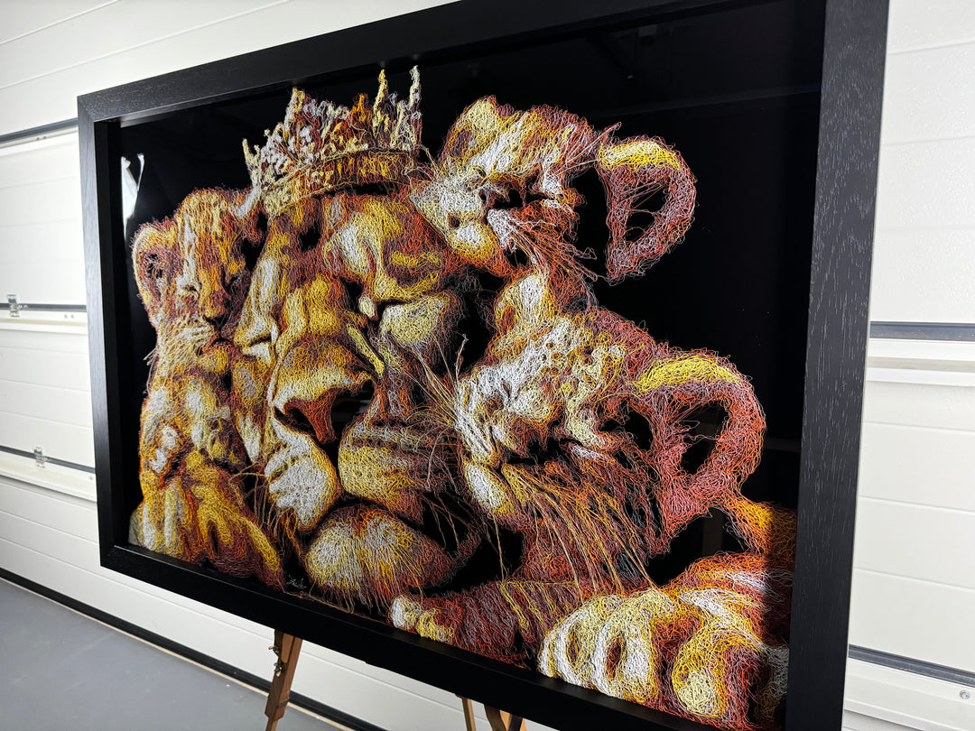 A richly textured injected-scribble artwork depicting a majestic lion wearing a crown, resting peacefully with three lion cubs nestled against him. The composition glows with warm tones of gold, amber, orange and cream, set against a deep black background that enhances the dimensional, thread-like detailing.