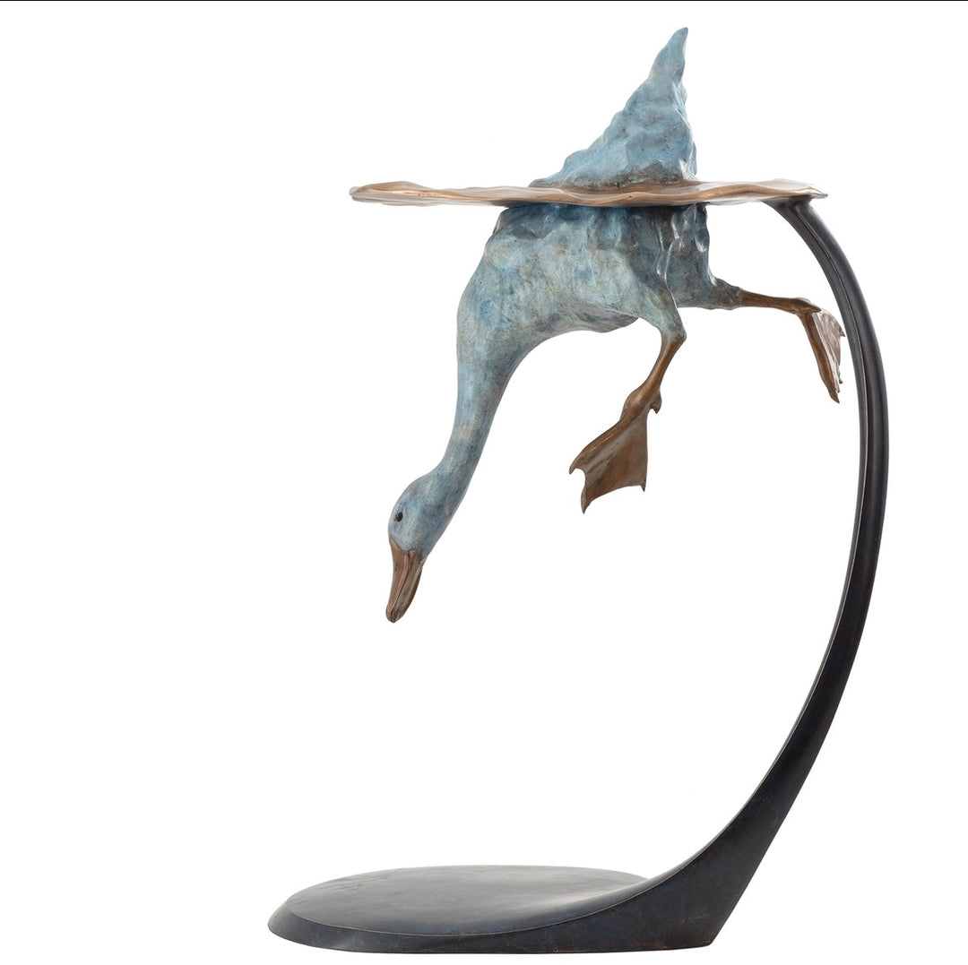 Playful bronze sculpture of a duck diving underwater, with only the rear and feet above a rippled surface, supported by a curved bronze stand — full of character and movement.