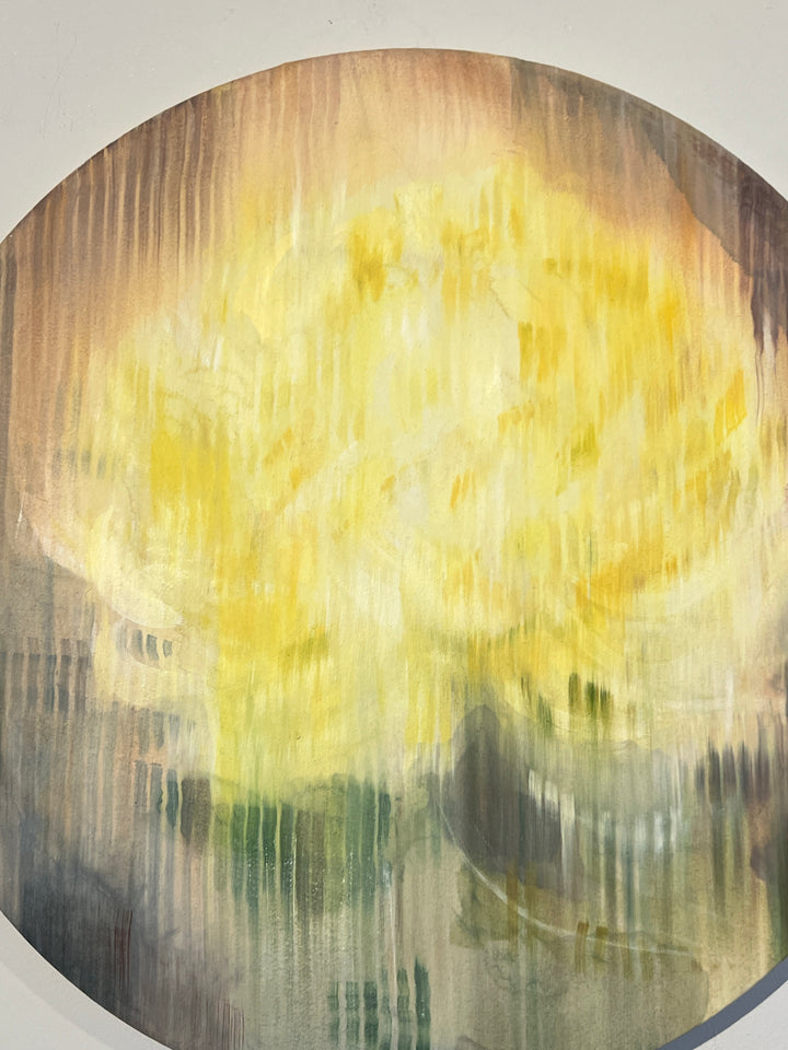 Abstract round painting of a yellow flower with blurred vertical texture on muted background.