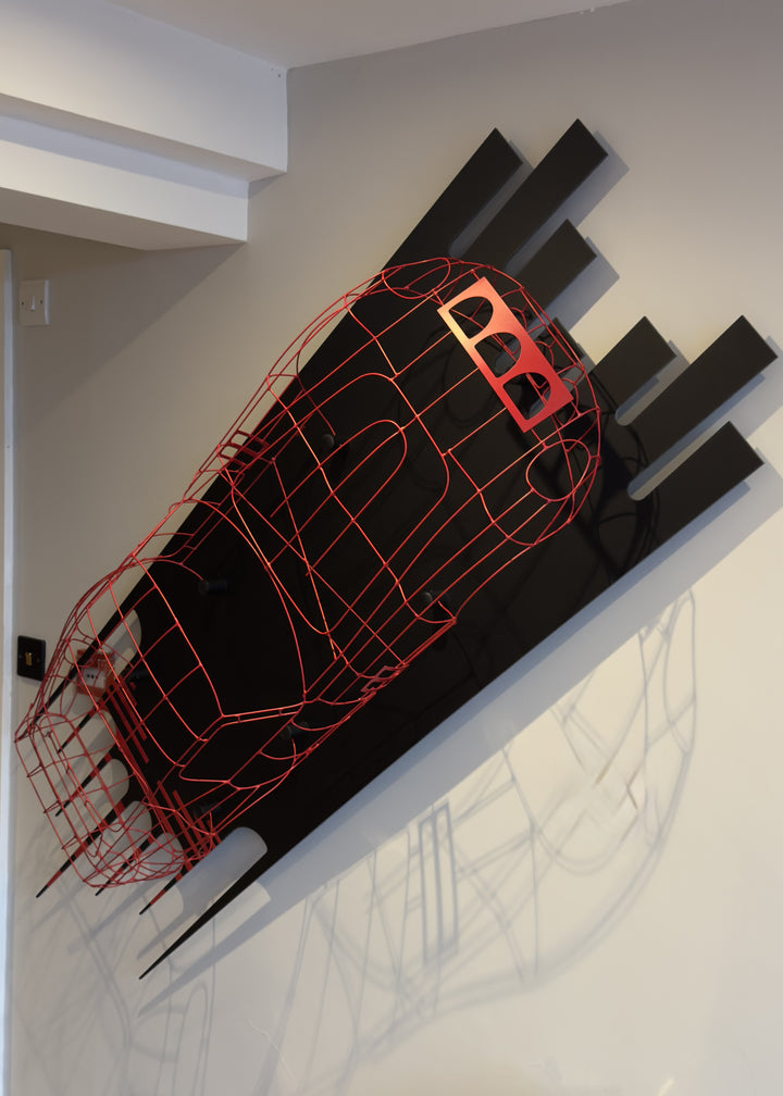Handcrafted red wire sculpture of the Ferrari 250 GTO by Chris Twitchell, inspired by the original coachbuilder’s buck used to form the legendary 1962 Series 1 body. Finished in Rosso Chiaro red, this intricate wall-mounted artwork captures the elegance, form, and aerodynamics of Scaglietti’s design through sculptural craftsmanship and precision engineering.