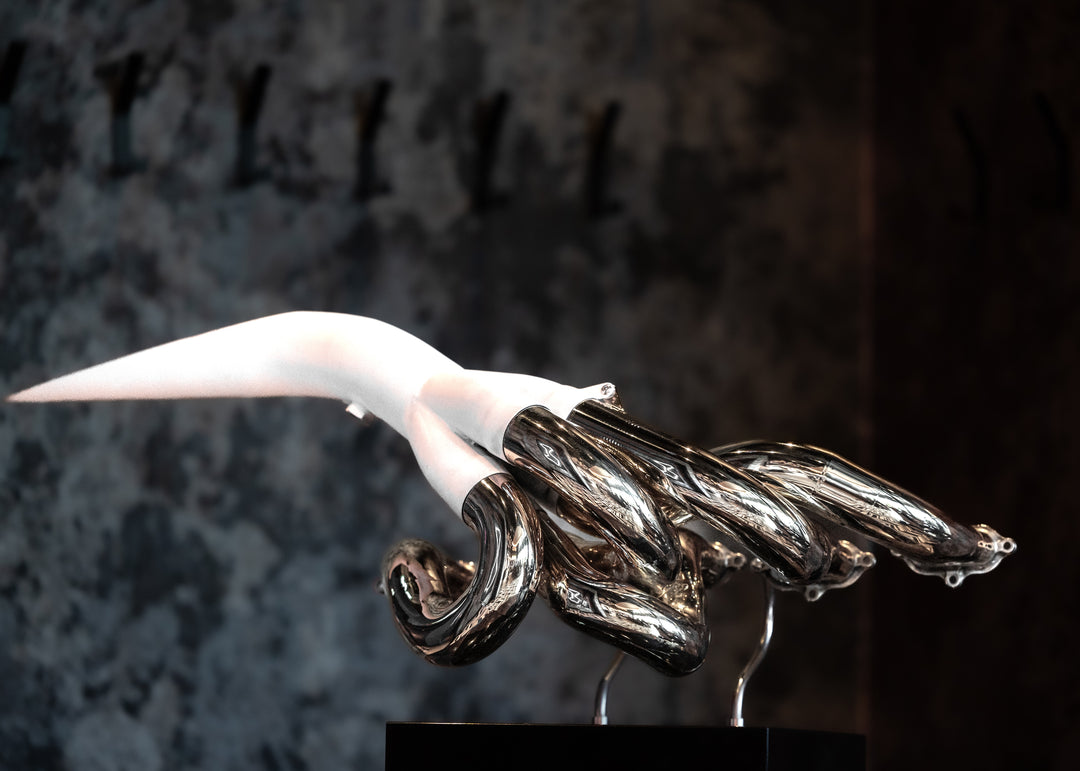 One-of-one sculpture by Mike O’Connor created from the authentic, race-used exhaust system of the 2001 Jordan EJ11 Formula One car. The polished Inconel structure gleams with precision and craftsmanship, while the internal surfaces are plated in 24-karat gold—a tribute to the heat and resonance of the V10 era. Mounted on a sleek black plinth