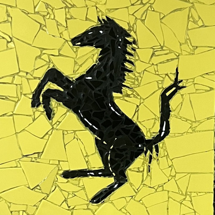 Two handcrafted ceramic mosaic wall artworks featuring Ferrari and Porsche badges, created as bespoke commissions. Each piece is made from hand-cut ceramic tiles in yellow, red, black, white, and grey, celebrating classic motorsport design and automotive heritage through contemporary mosaic craftsmanship.