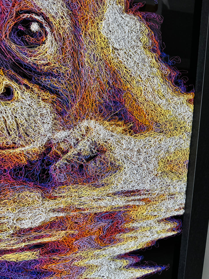 A vibrant textured artwork of a baby orangutan leaning over shimmering water, created with Zalini’s intricate injected-scribble technique, featuring flowing multicoloured lines, bright orange fur, vivid purples and blues, and a mirrored reflection across a glossy black surface.