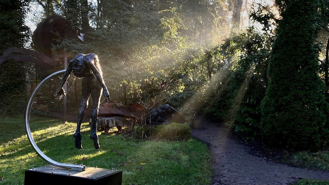 I SPIRIT by Teresa Wells – a monumental one-off bronze sculpture of a nude female figure, arched backwards in a powerful, suspended pose, supported mid-air by a sweeping stainless steel arc anchored to a stone base. Standing 190cm high, the figure’s elongated form captures anatomical detail, strength, and vulnerability, with a dark patinated bronze finish that contrasts against the polished steel support. A contemporary statement of transformation and human resilience.