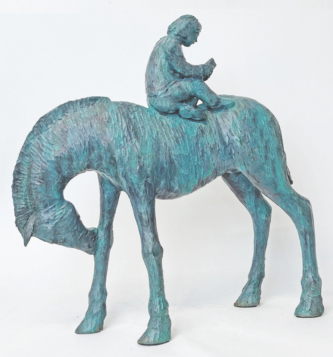 Lost in the Calmness of Reading by Ian Marlow - a limited edition bronze sculpture depicting a young figure seated atop a grazing horse, absorbed in a book, with a textured surface and serene presence.
