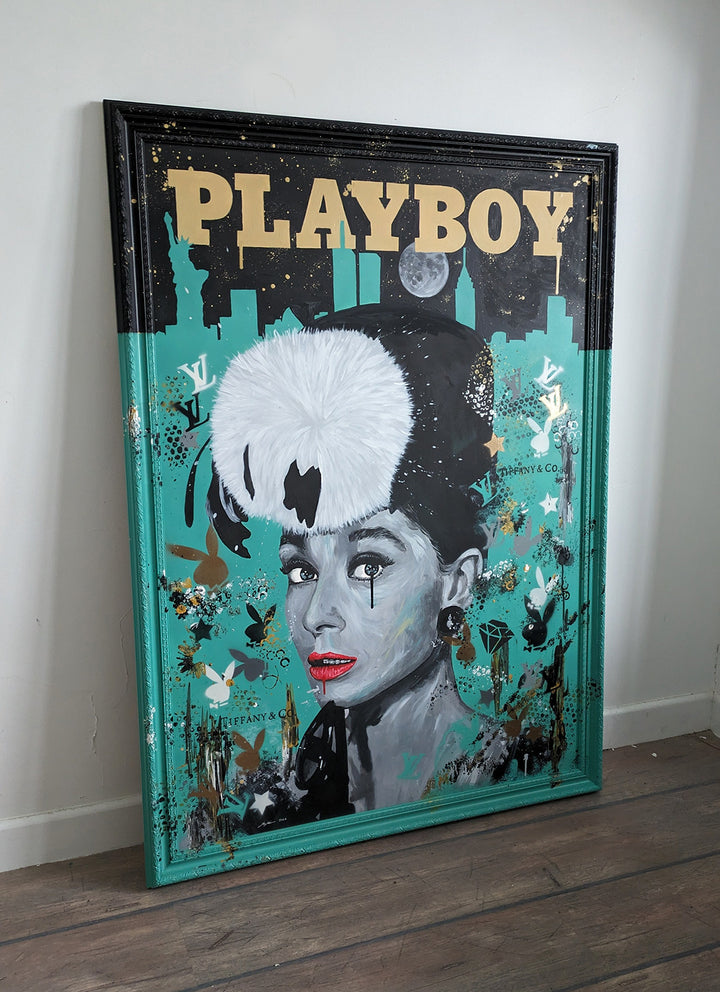 Original painting of Audrey Hepburn by Ian Salmon, featuring a monochrome portrait with vivid red lips and a bold white fur hat, set against a Tiffany blue background with the New York skyline, gold "Playboy" title, and luxury brand motifs.