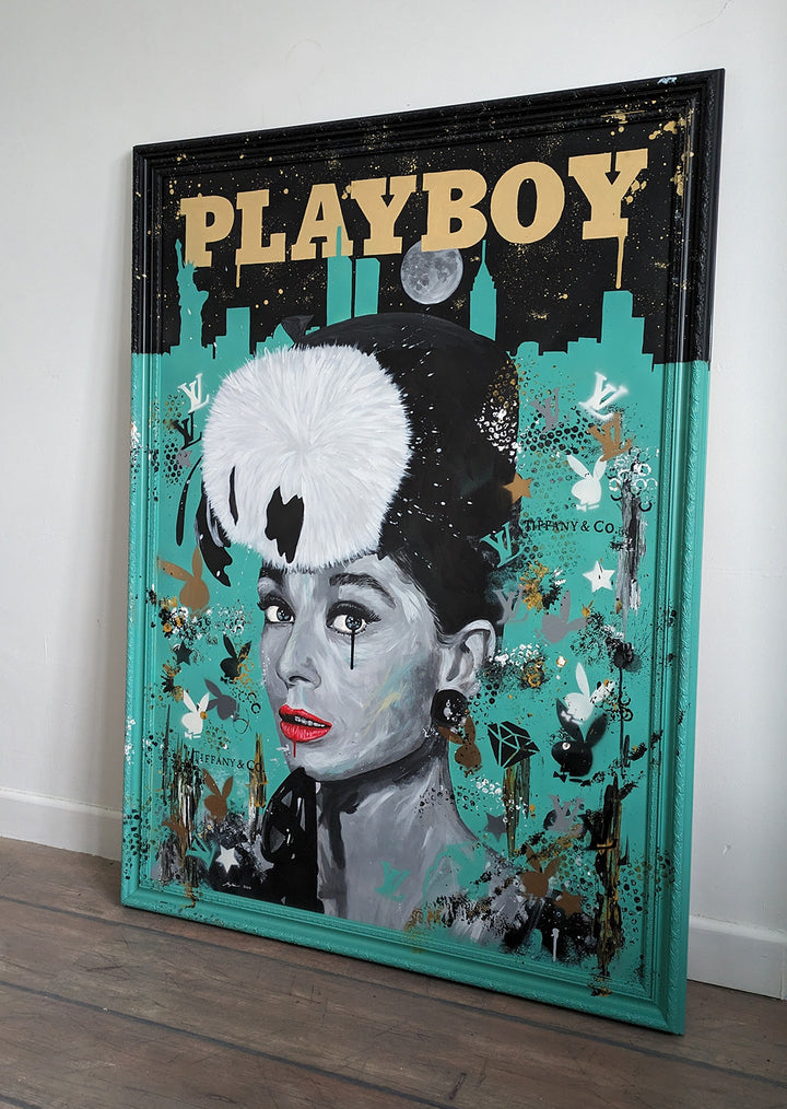 Original painting of Audrey Hepburn by Ian Salmon, featuring a monochrome portrait with vivid red lips and a bold white fur hat, set against a Tiffany blue background with the New York skyline, gold "Playboy" title, and luxury brand motifs.