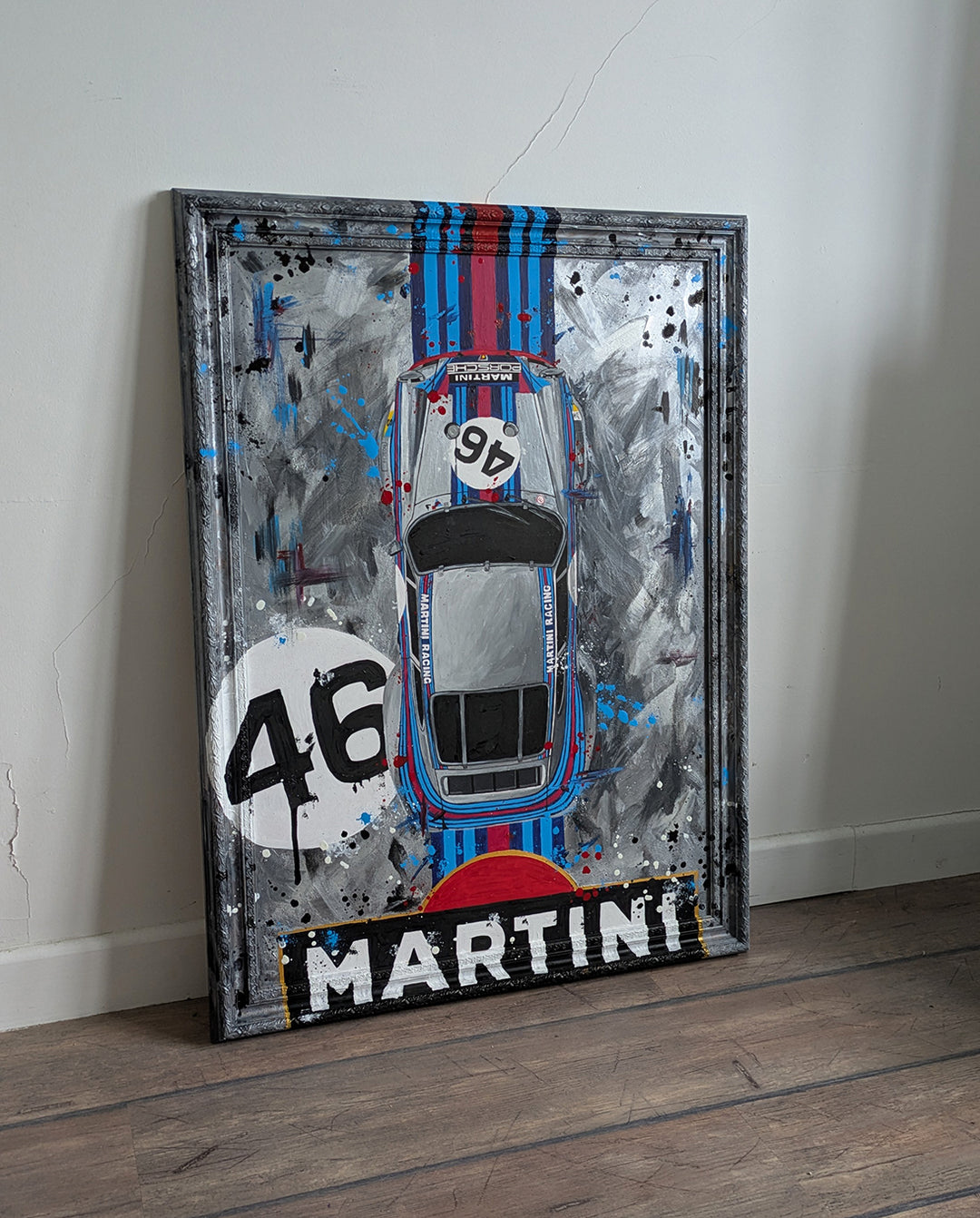 Original painting of a 1973 Porsche 911 Carrera 3.0 RSR in Martini Racing livery, shown from a top-down view with bold racing stripes and number 46, set against a textured abstract grey background and framed in a custom-painted frame.