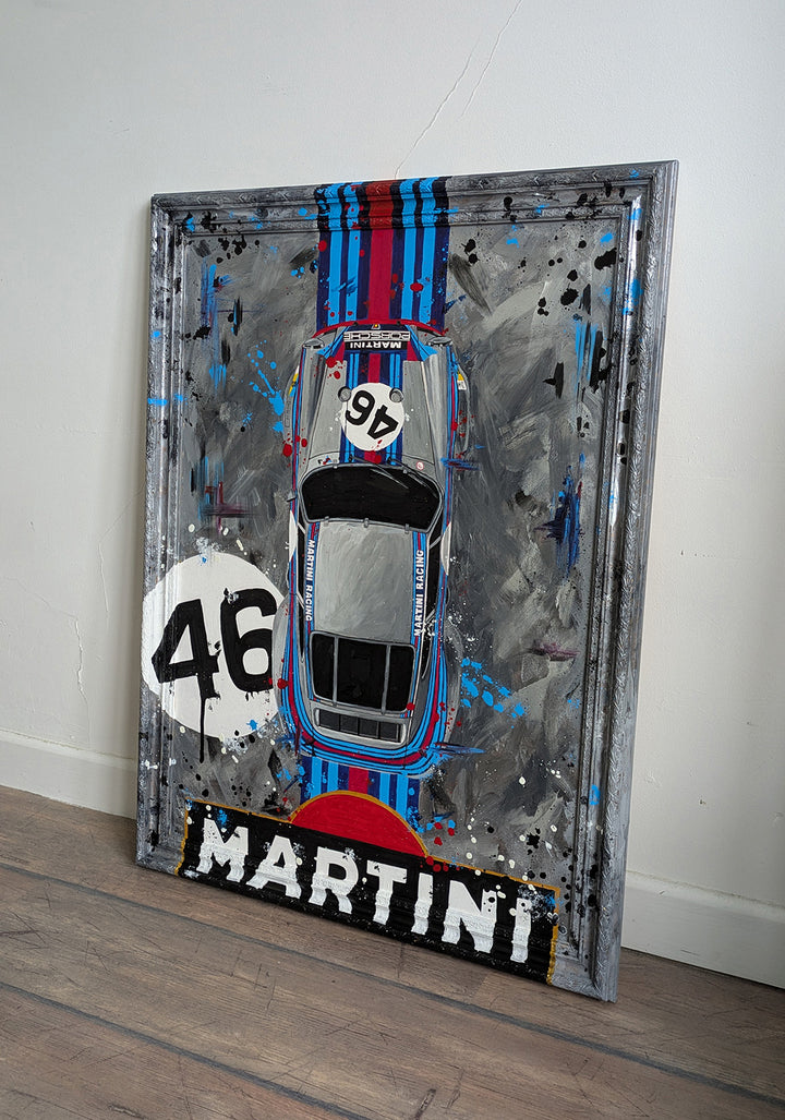 Original painting of a 1973 Porsche 911 Carrera 3.0 RSR in Martini Racing livery, shown from a top-down view with bold racing stripes and number 46, set against a textured abstract grey background and framed in a custom-painted frame.